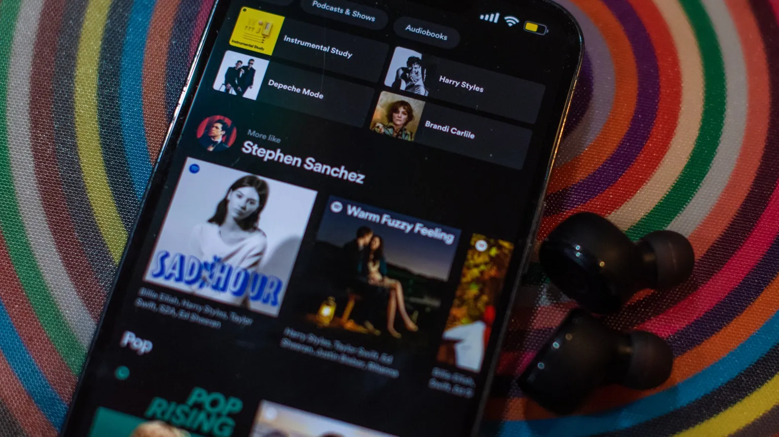  A phone showing the Spotify app with various musicians
