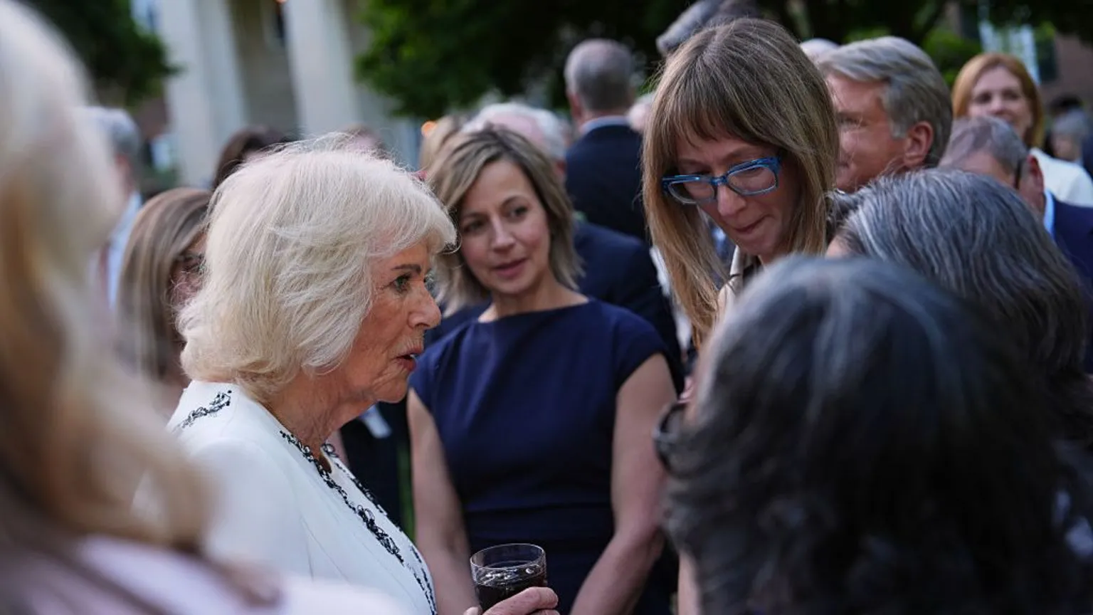  Queen Camilla greets guests during a garden party at the British Embassy in Washington DC.
