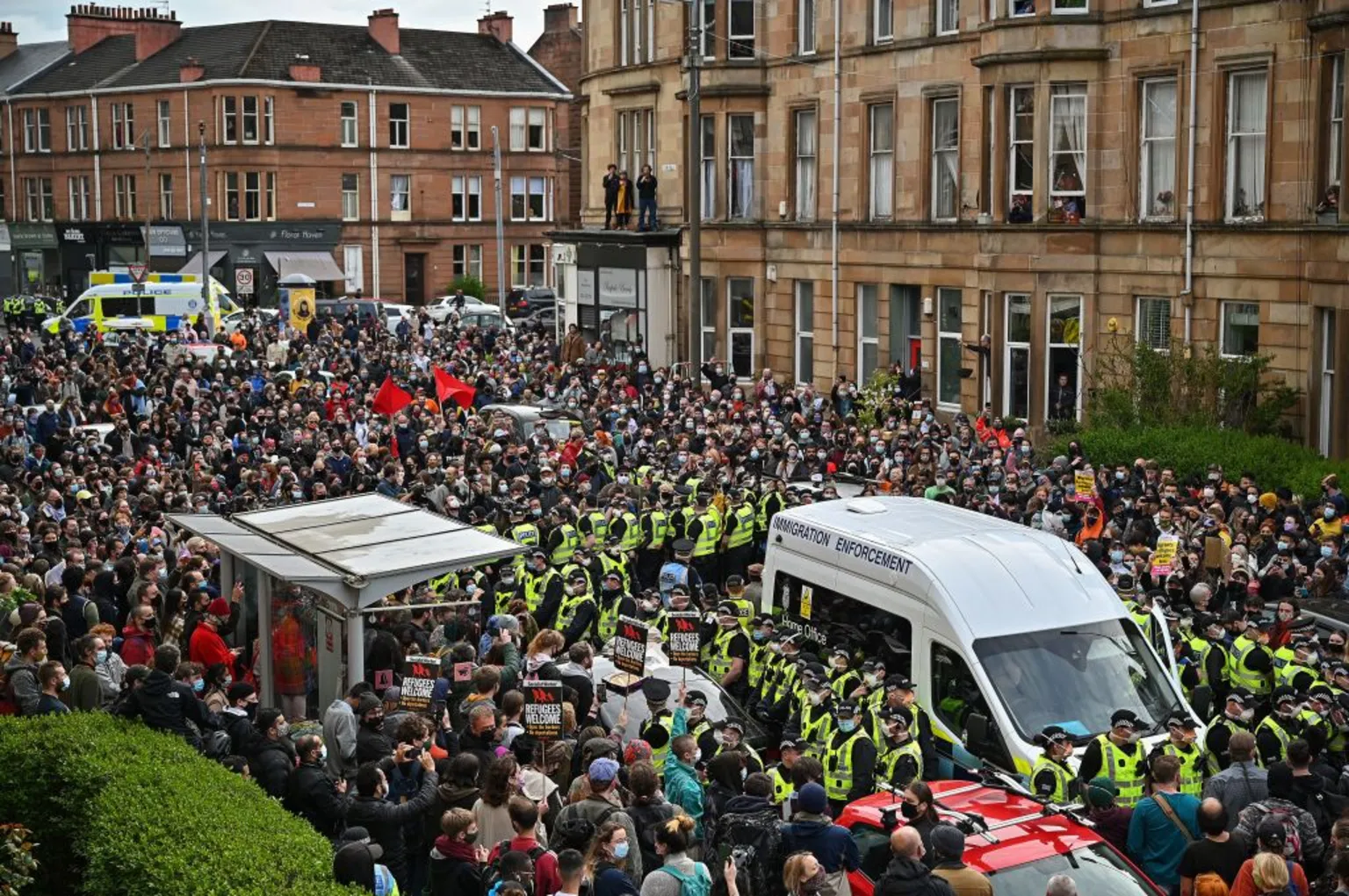  Hundreds of protestors surround a immigration enforcement van in the southside of Glasgow as they wait for police to escort two men detained by the Home Office