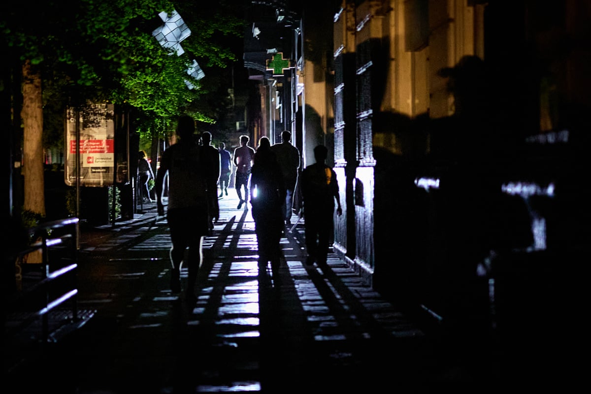 People walk down a street during a blackout in Spain