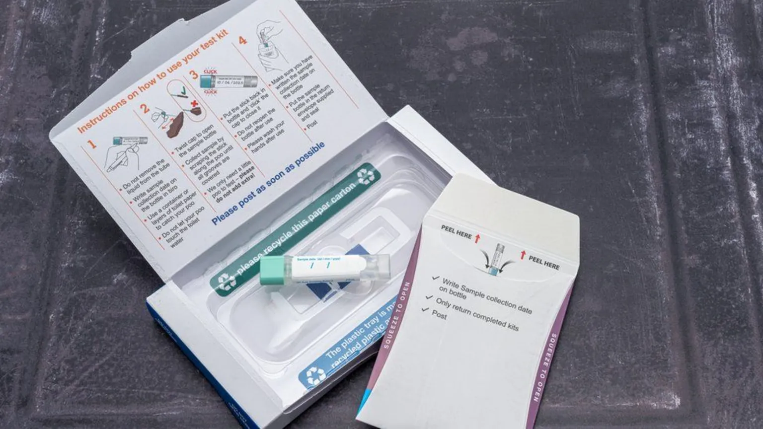  An NHS bowel cancer home test kit. A small cardboard box has printed instructions on the inside of the lid about how to take a sample and return it 