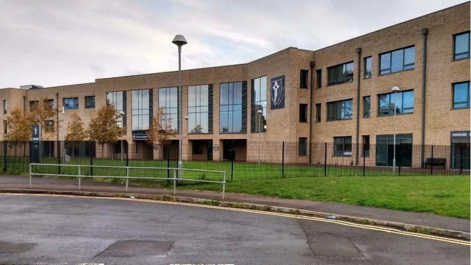 LDRS The outside of Caldicot School in Monmouthshire. A beige three-storey brick building, with a flat roof and large glass windows. There are some small trees and a grassy area immediately in front of the building.