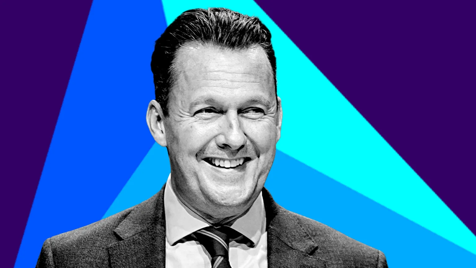 Russell Findlay is wearing a shirt and tie. He is pictured in black and white, against a colourful background. 