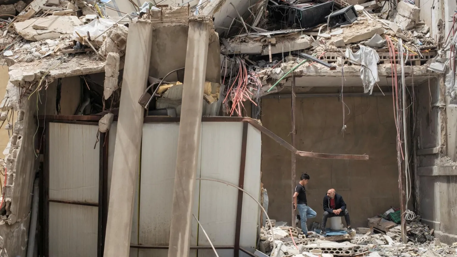  Two men talk amid the rubble of a destroyed building in Tyre, southern Lebanon (28 April 2026)