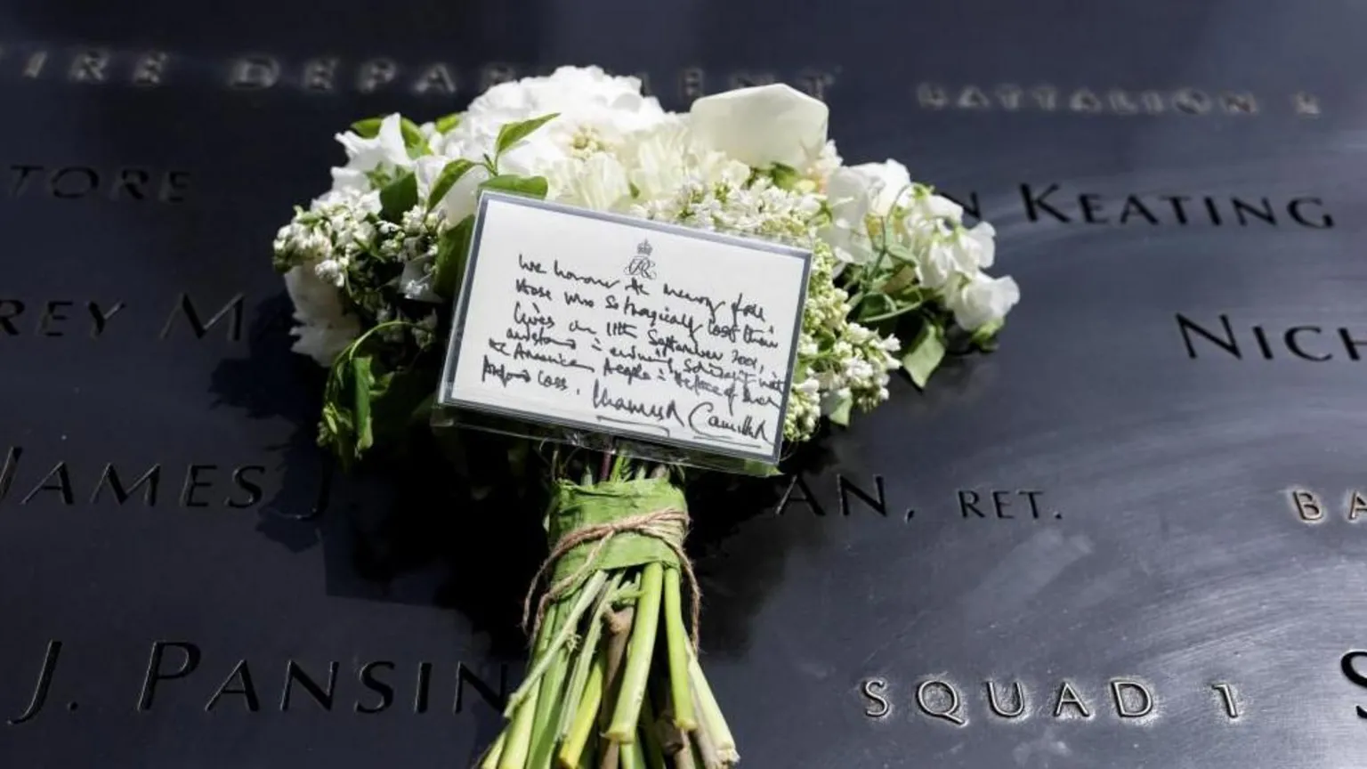  A bouquet of white flowers with a note from King Charles and Queen Camilla lies at the 9/11 Memorial 