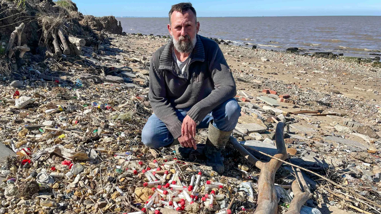 Yvette Austin/BBC Fossil hunter Daniel Hogburn with a small sample of vials he's found 