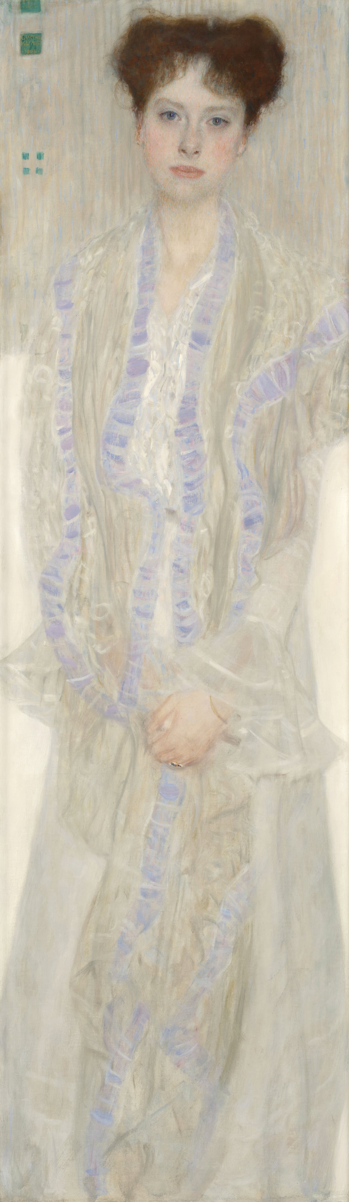 Gustav Klimt’s portrait shows a young woman seated with hands clasped, wearing a flowing white dress