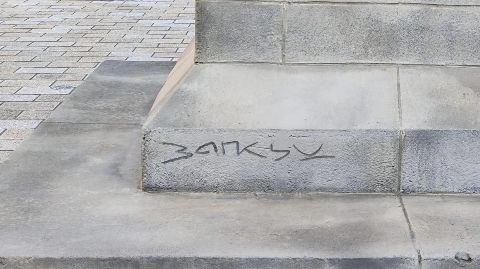 The letters B A N K S Y scrawled into a stone plinth base