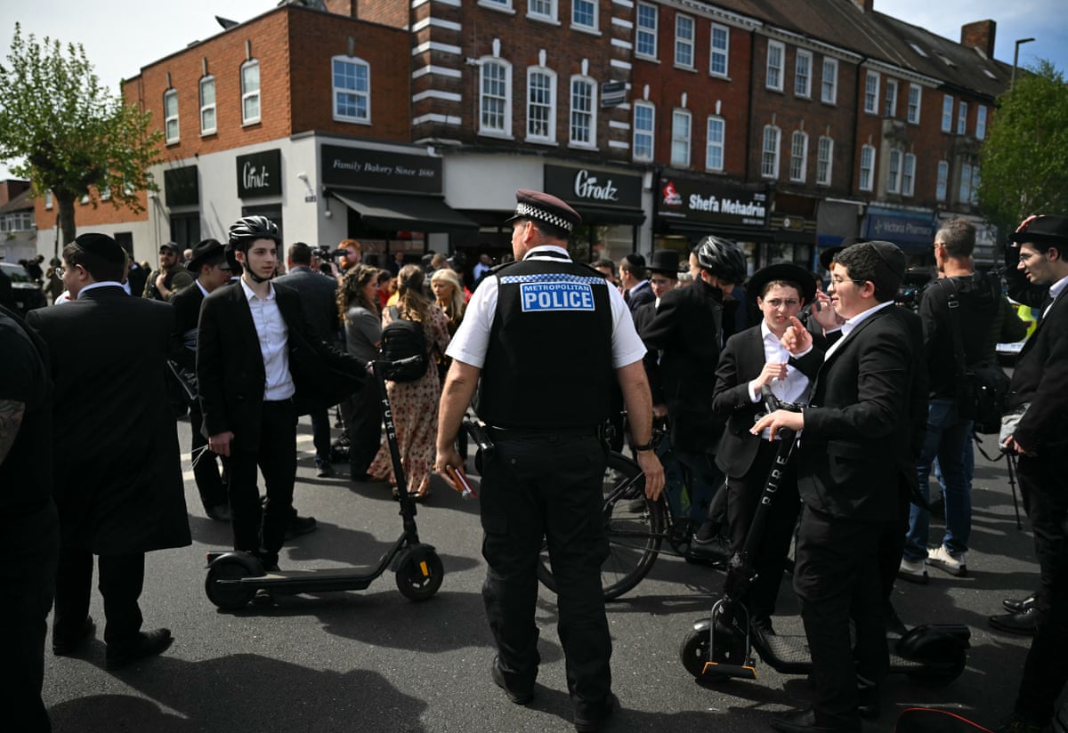 A police officer and members of the Jewish community near the scene of the stabbings. 