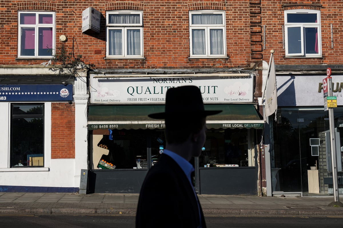 A Jewish man walking down a street in Golders Green.