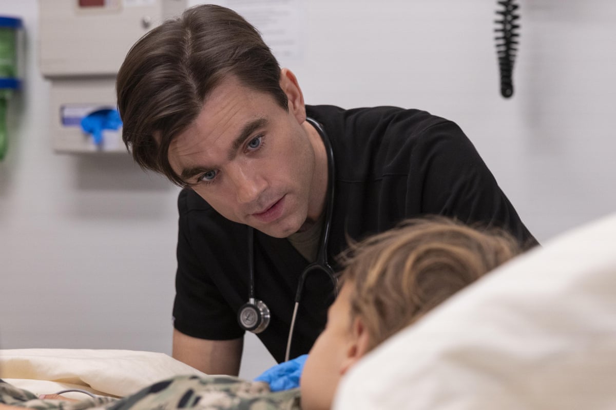 A doctor in black scrubs talking to a patient.