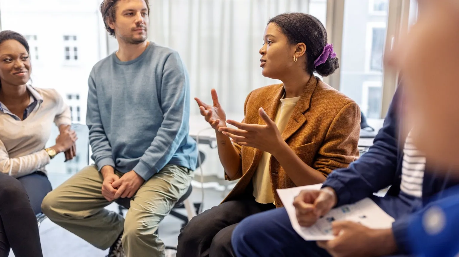  A stock shot of a group of people seated, holding a discussion. 