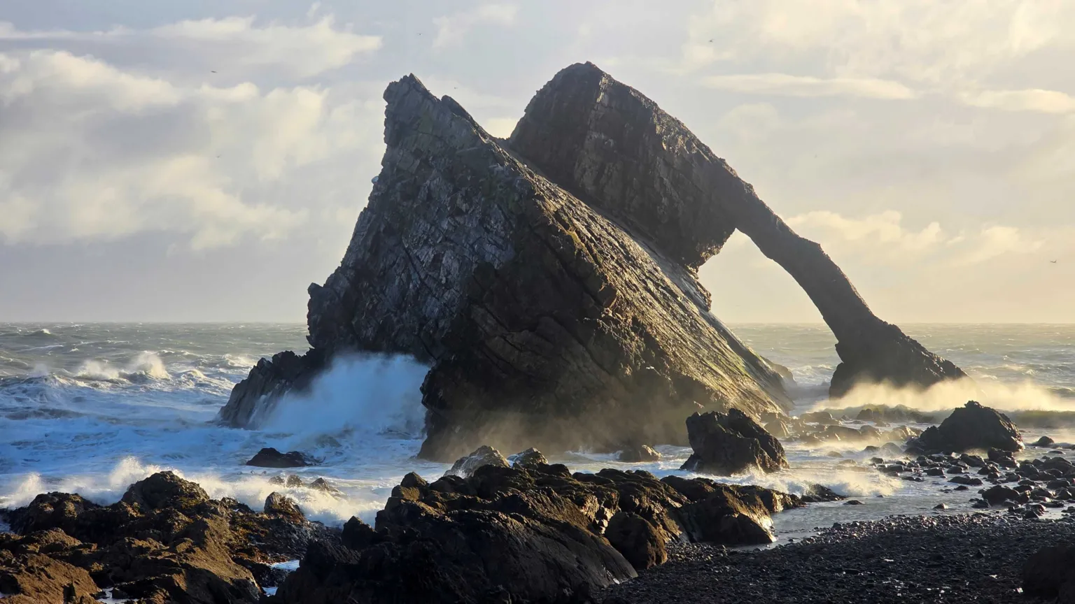 Robert Kitchen The Bow Fiddle Rock with waves crashing against it. 