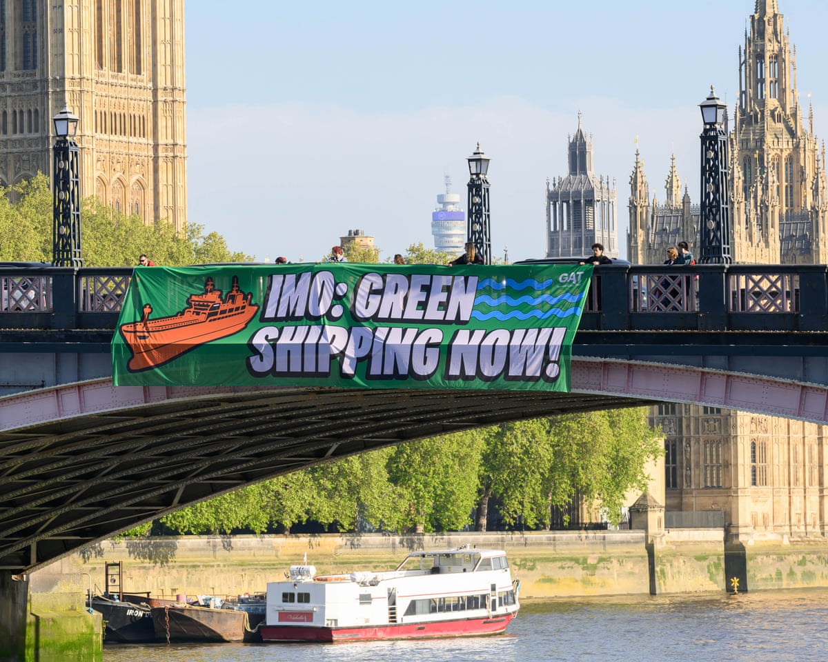 A banner on the side of a bridge reads ‘IMO: Green shipping now!’