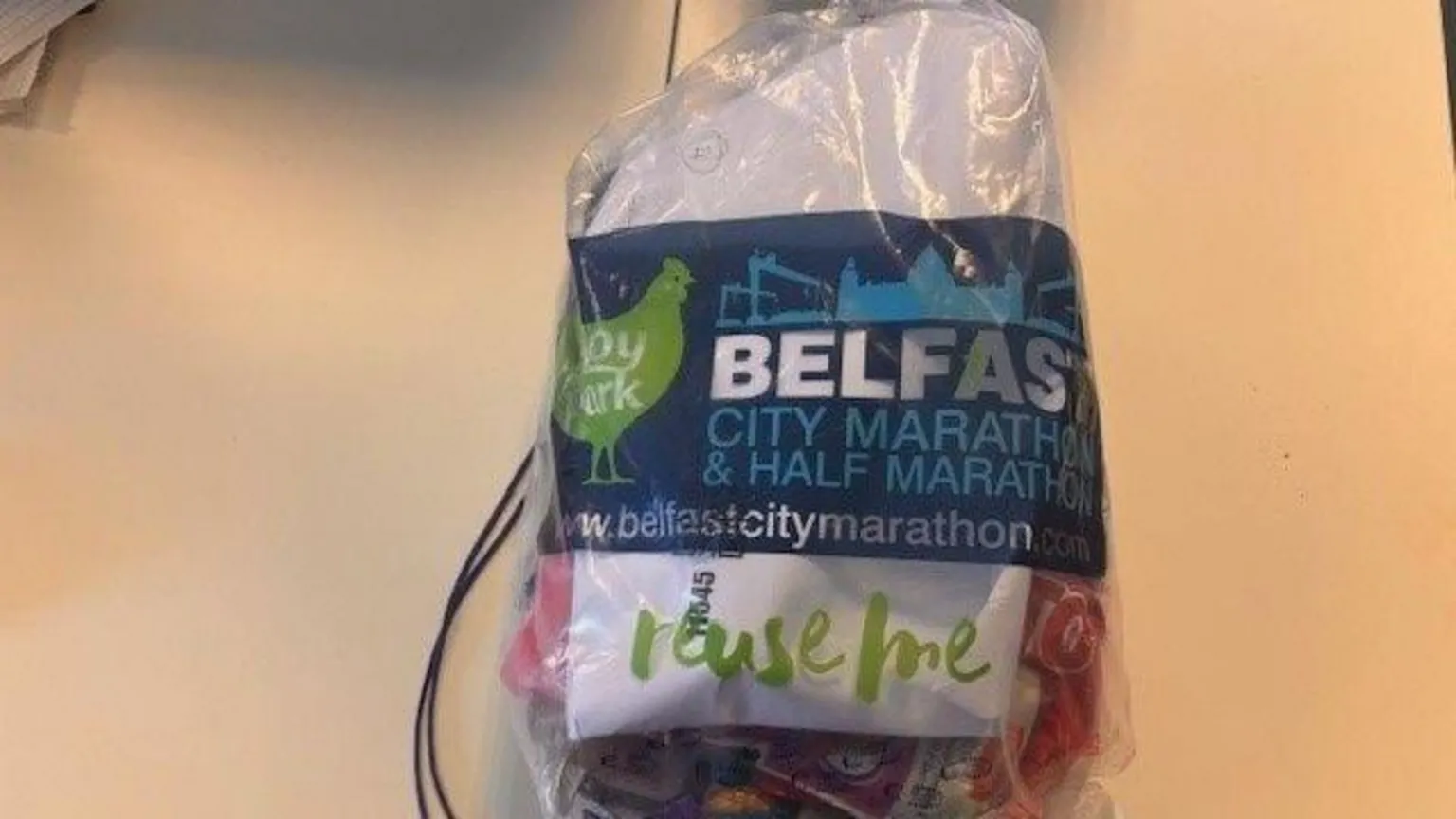 The Belfast marathon plastic bag. Visible is some food and a piece of paper. 