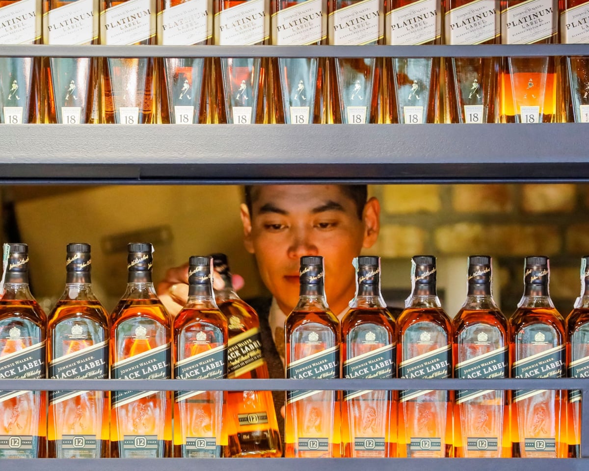 A bartender takes a bottle of Johnnie Walker whisky at a bar in Almaty, Kazakhstan.