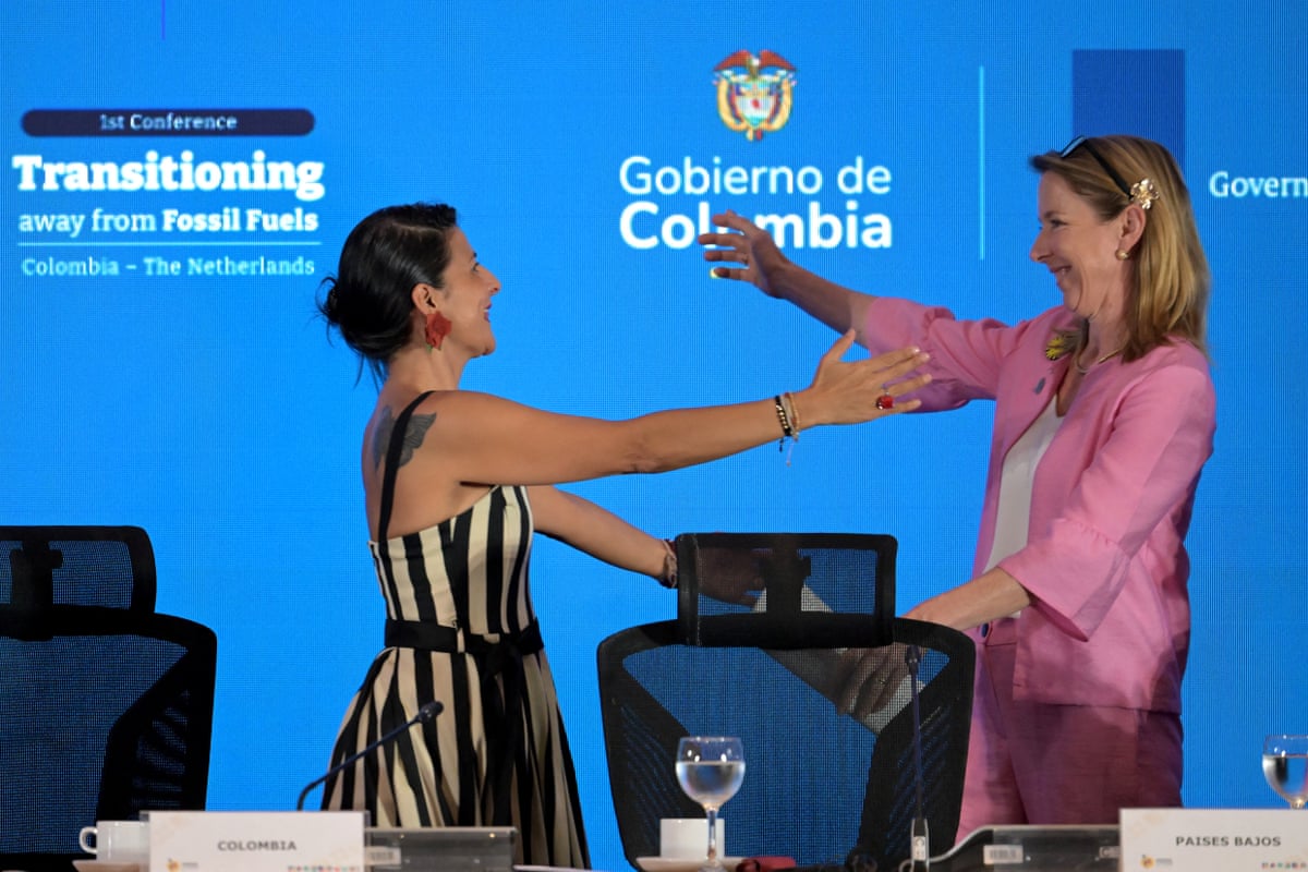 Torres and Van Veldhoven stand and make to embrace on stage