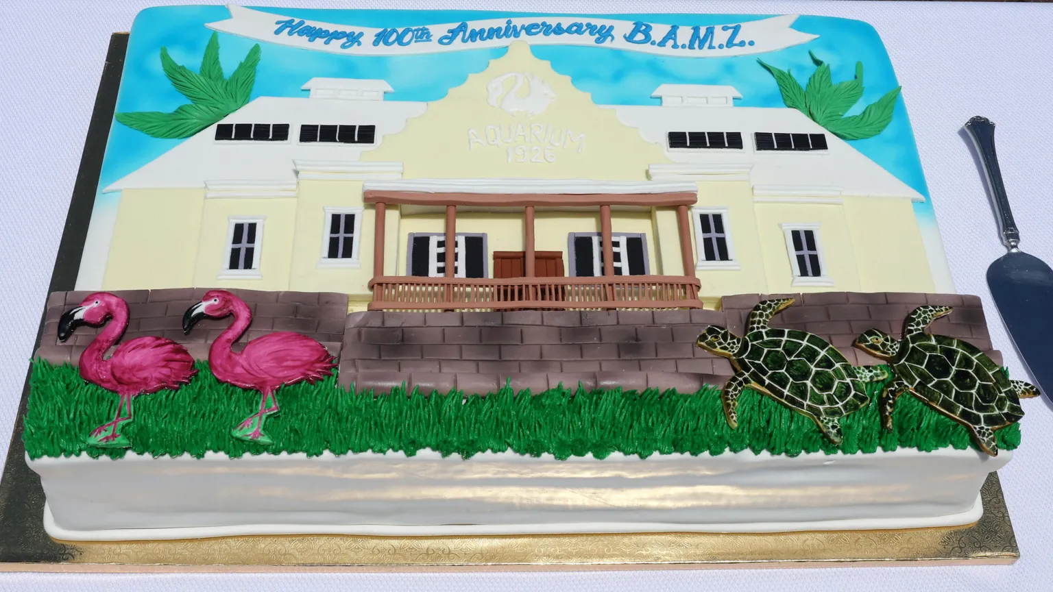  A cake with icing depicting the museum building. There are also two turtles and flamingos made out of icing