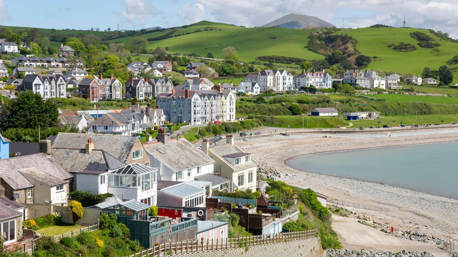  Criccieth in Gwynedd. Houses on rolling green hills overlook a pebble beach