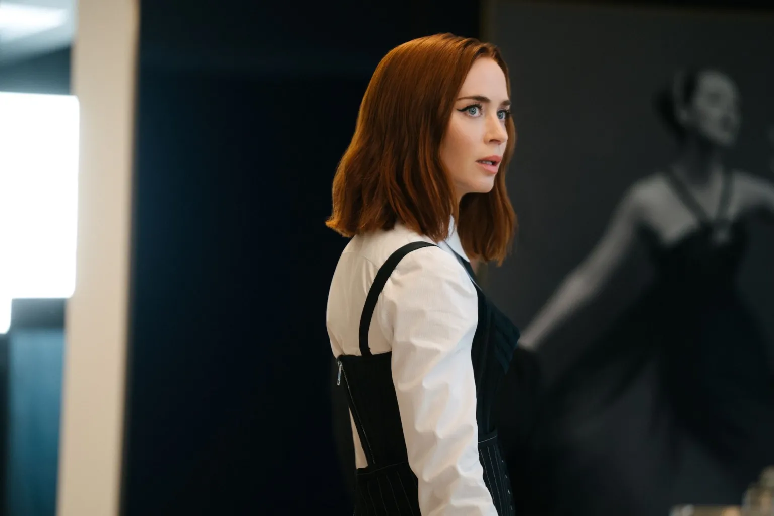 Walt Disney Studios Side-on image of Emily Blunt wearing a white shirt and black dress.