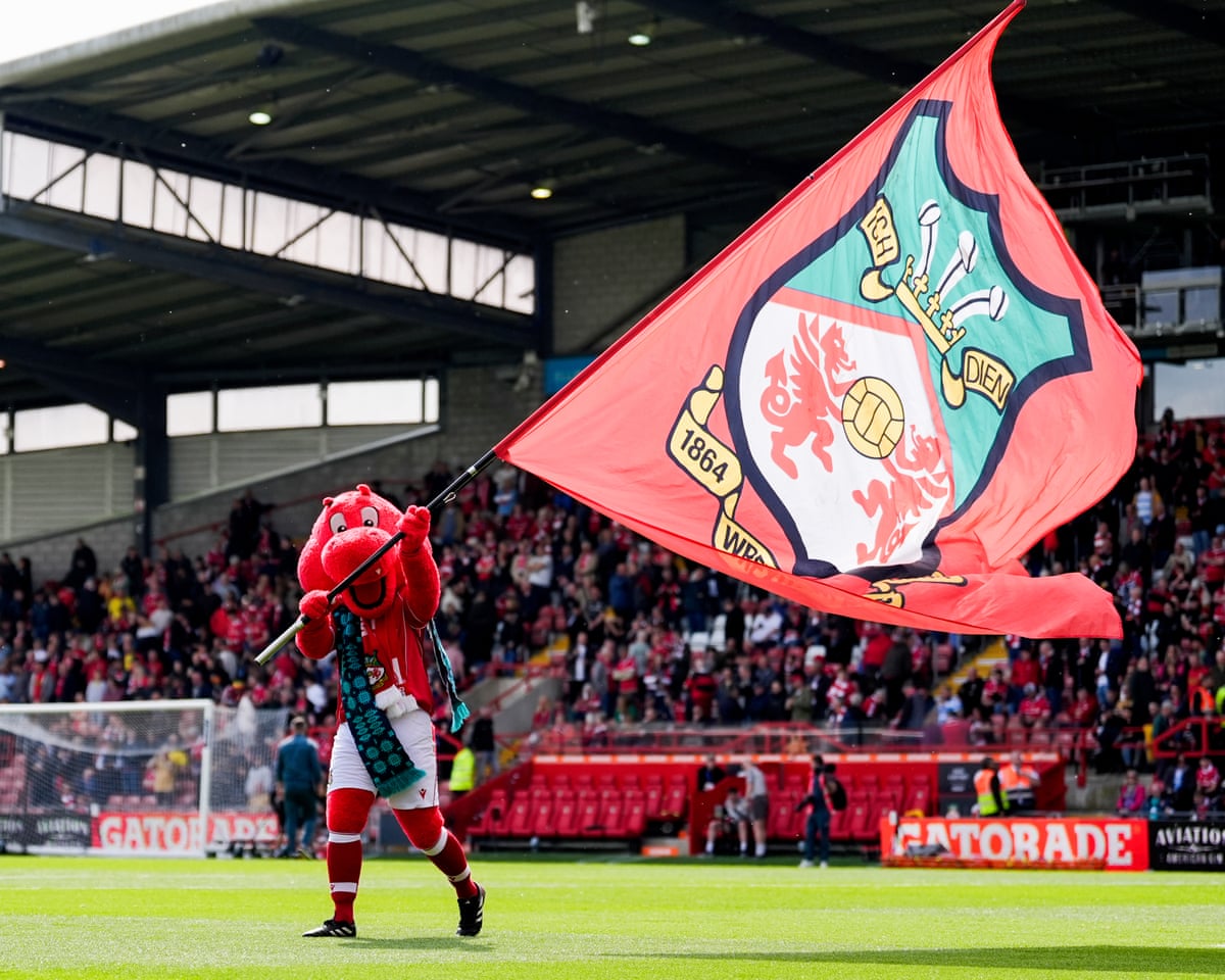 Wrexham mascot, Wrex the Dragon, waves a flag.