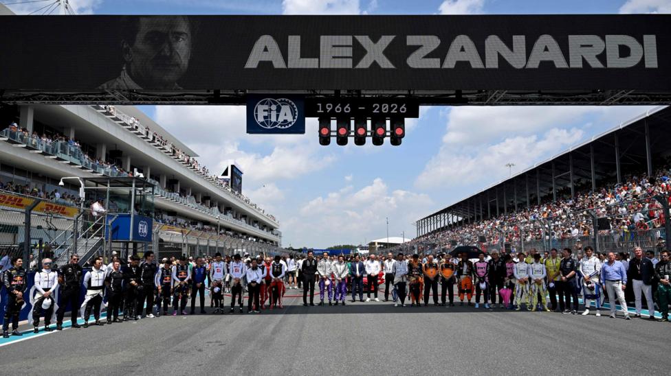 Drivers and team members gather on the grid for a minute's silence to pay tribute to Alex Zanardi, the former F1 driver, IndyCar champion and Paralympic champion who died on Friday, aged 59. Zanardi's image is visible on the electronic screen above the start-finish straight
