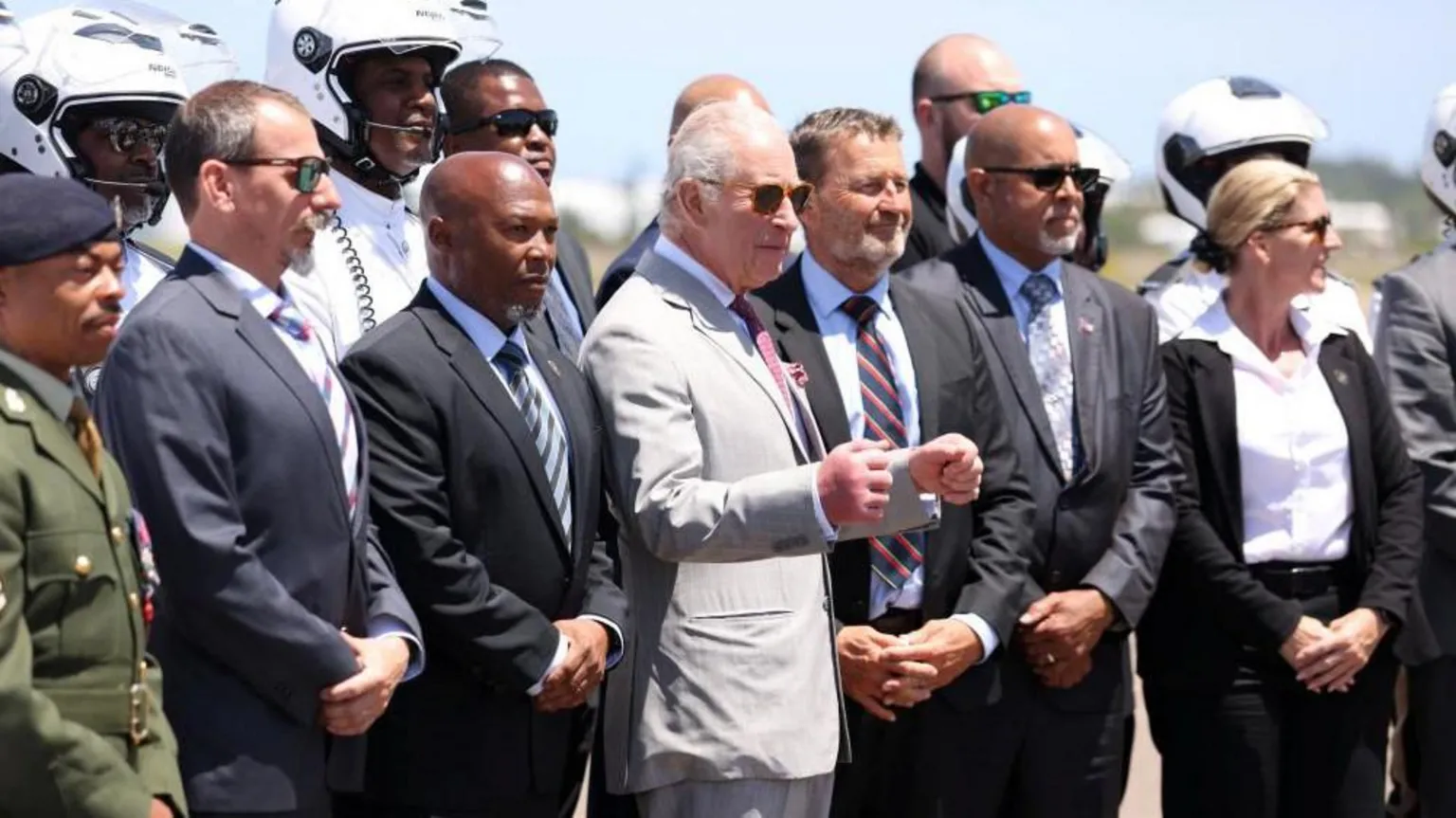 The King stands in front of a group of officials as he prepares to take a photo