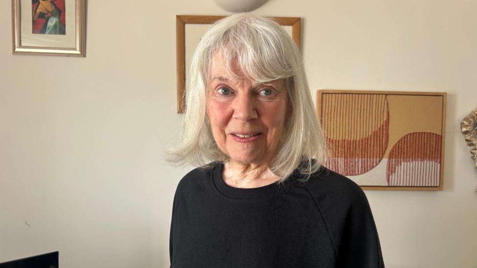 Roslyn Moore gyda gwallt gwyn a gwisgo siwmper ddu