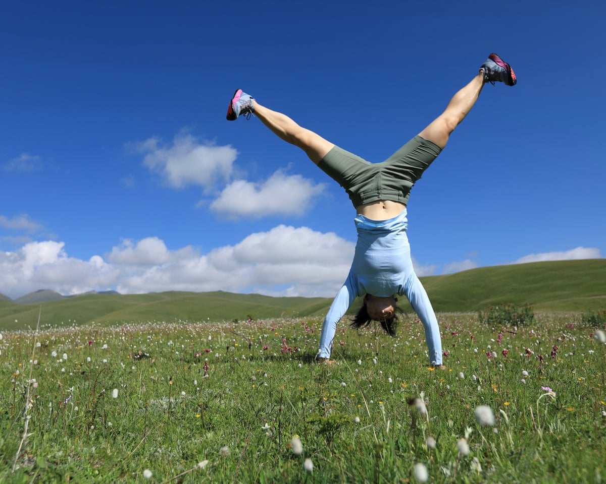 woman handstanding in a meadow