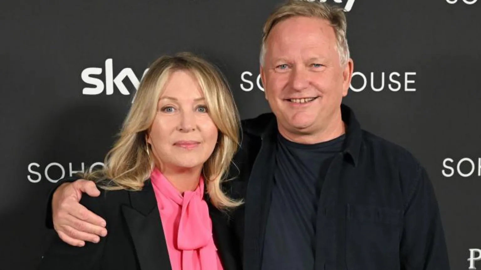  Kirsty Young - a woman with blonde hair, wearing a dark jacket and pink top, with Nick Jones, a man with short, light hair and wearing all dark clothing 