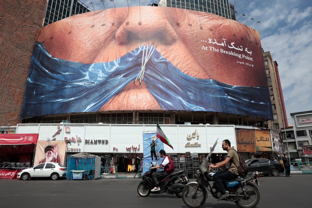 A billboard showing a blocked strait of Hormuz covering Donald Trump’s mouth