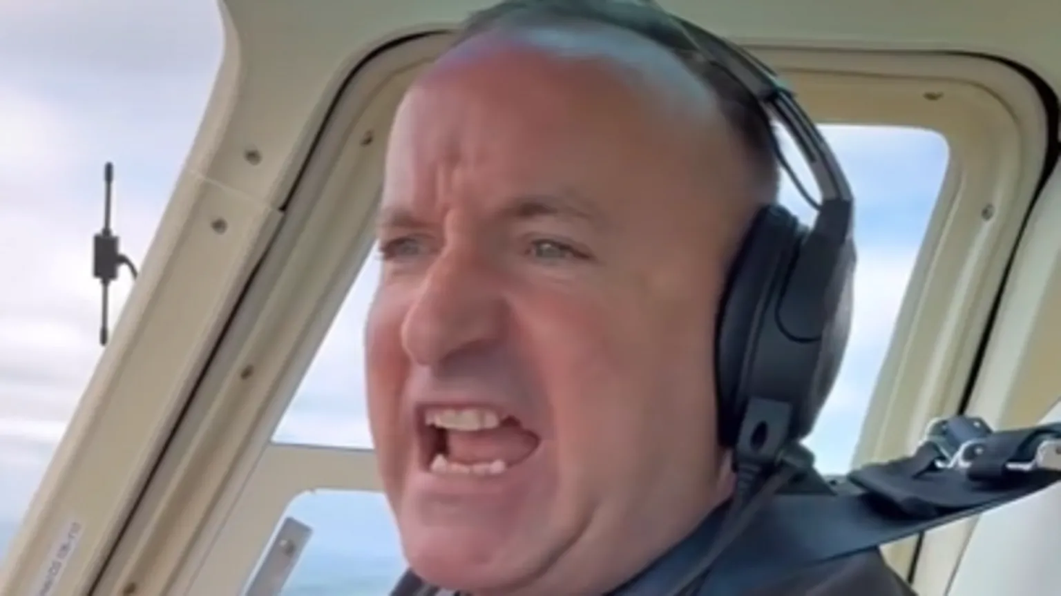 Dave Fishwick Dave Fishwick, wearing a headset and sitting in the cockpit of his helicopter, is narrating what he can see out of the window 