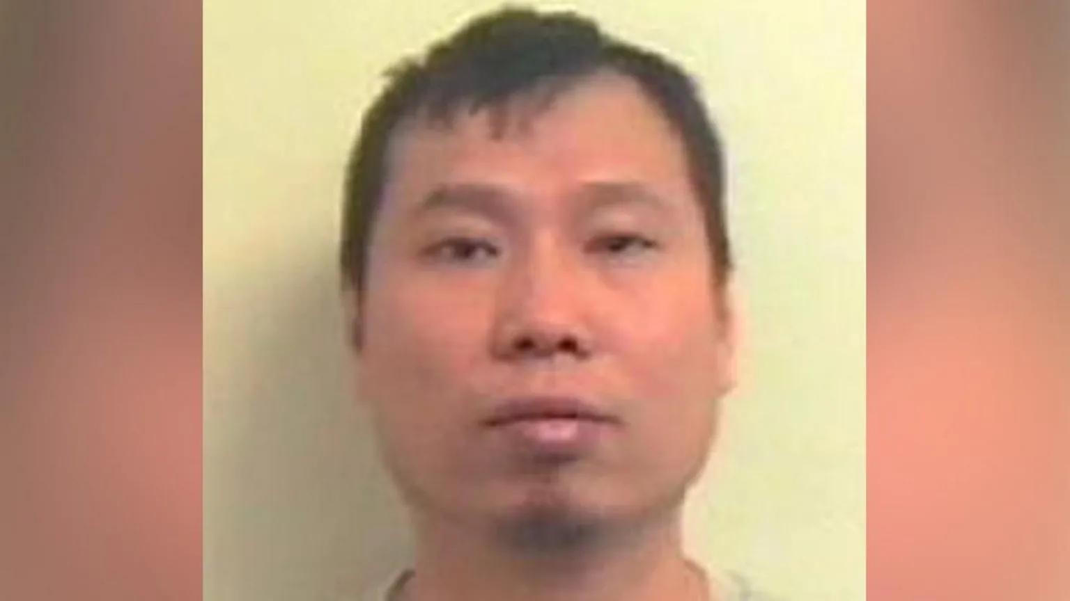 Police Scotland Grainy police mugshot of Zhi Min Chen, who has dark hair combed to the side. He has a serious expression on his face.