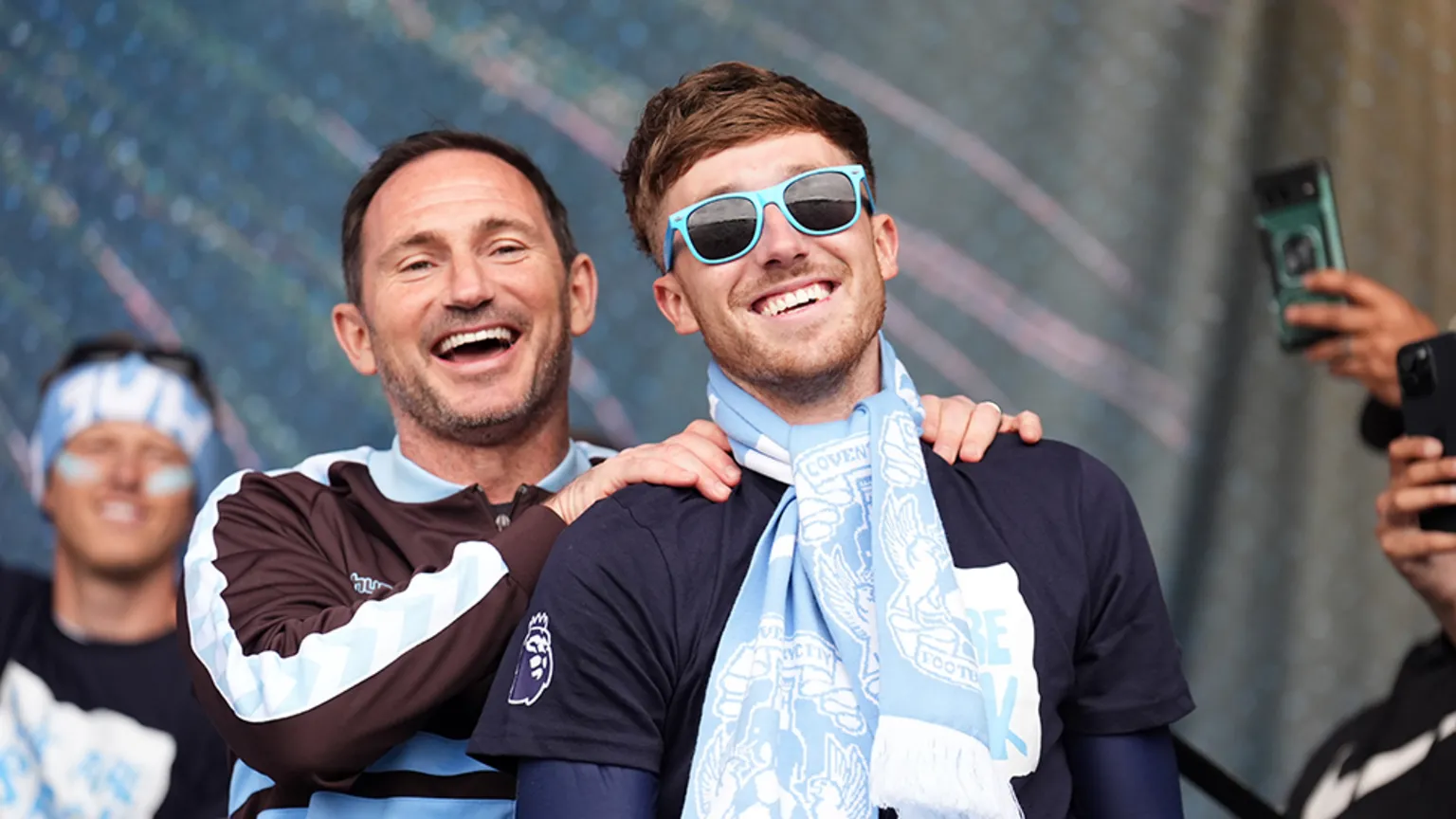  Frank Lampard is on stage with his hands on the shoulders of midfielder Josh Eccles