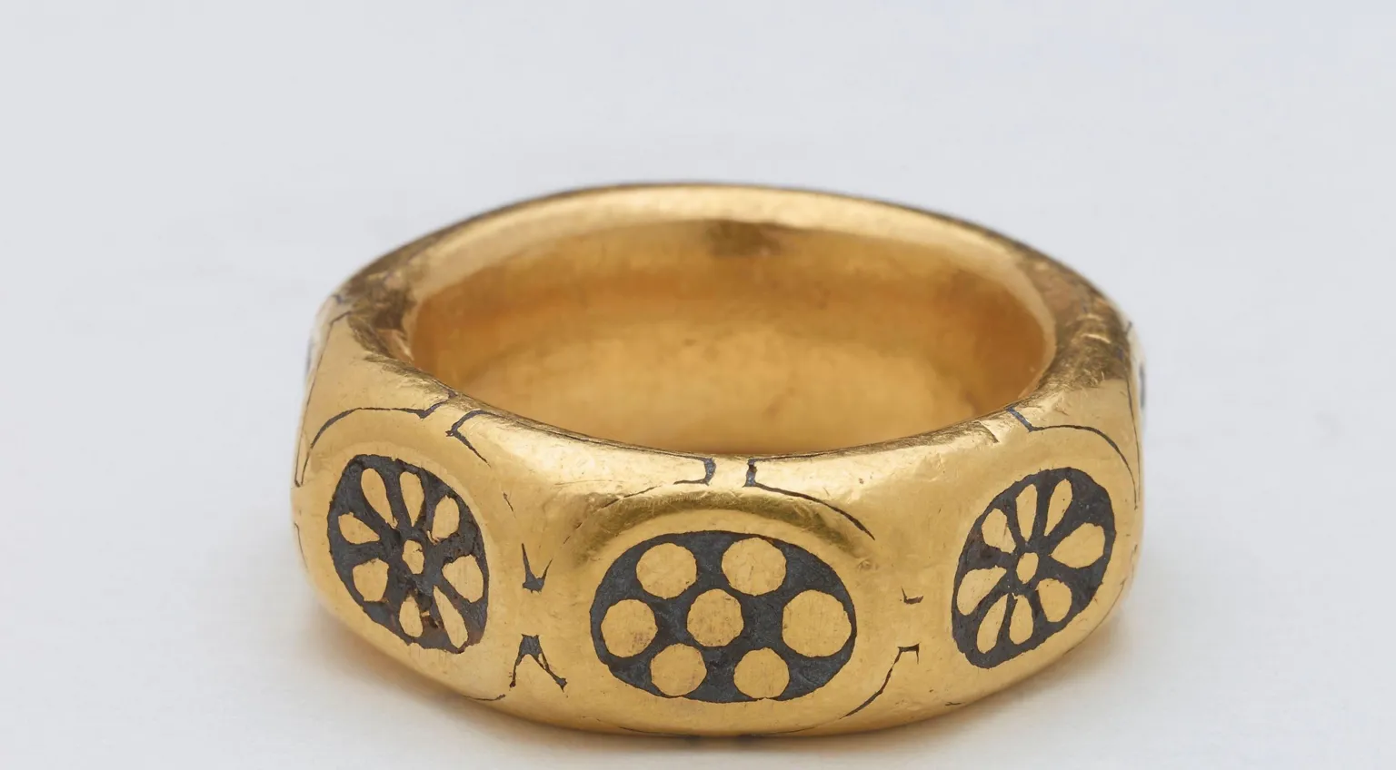 British Museum The large gold ring has eight sides. On each side is an inlet of lead with an ornate pattern.
