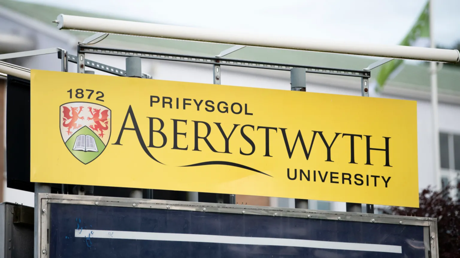  A yellow sign which has Aberystwyth University written on it.