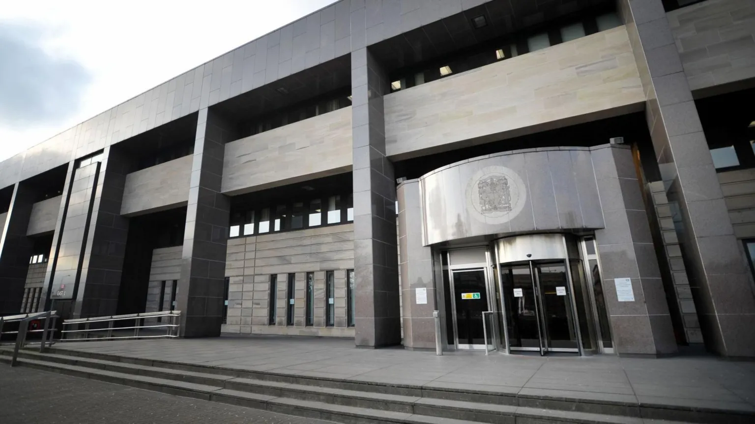  Glasgow Sheriff Court is a grey building with a rotating entrance and a brutalist exterior