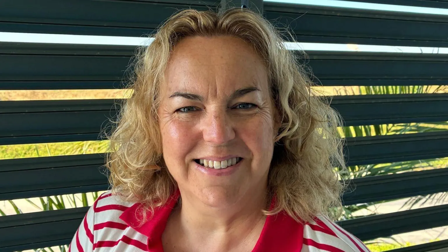 Sara Davies A woman with shoulder length blond hair and wearing a white and red stripey polo shirt smiling at the camera. It is a head and shoulders shot.
