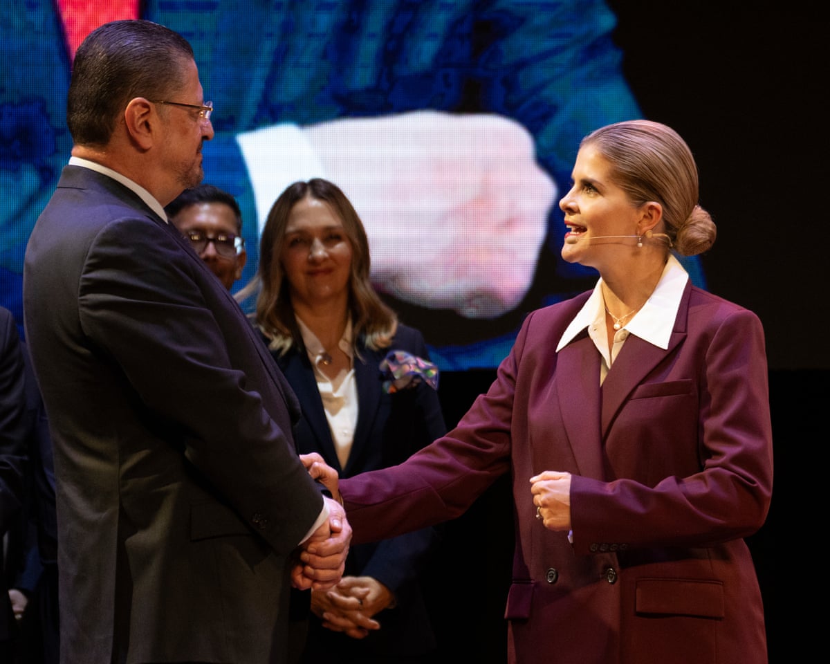 Laura Fernández shakes hands with Chavez on stage