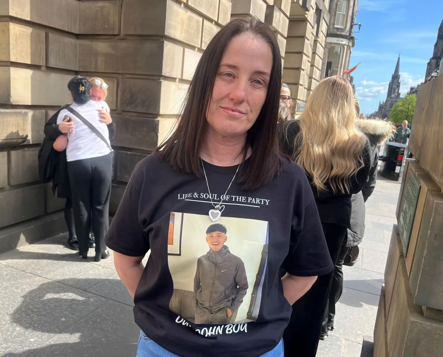 A woman with long dark dark hair wearing a black T shirt with a picture of John McNab on it