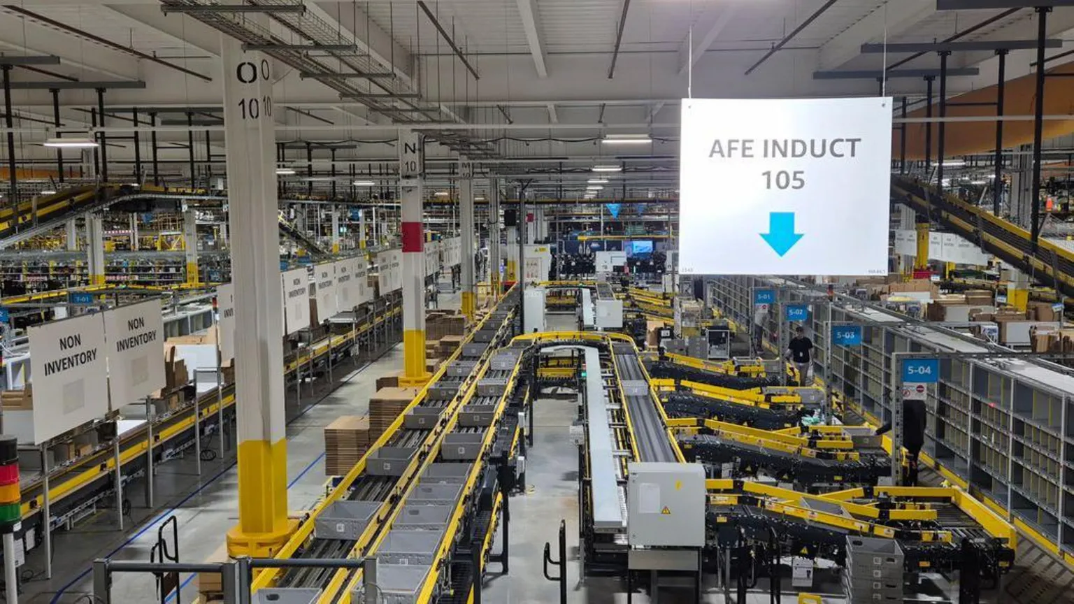 Inside Amazon's Darlington fulfilment centre with grey trays going along a yellow conveyor belt