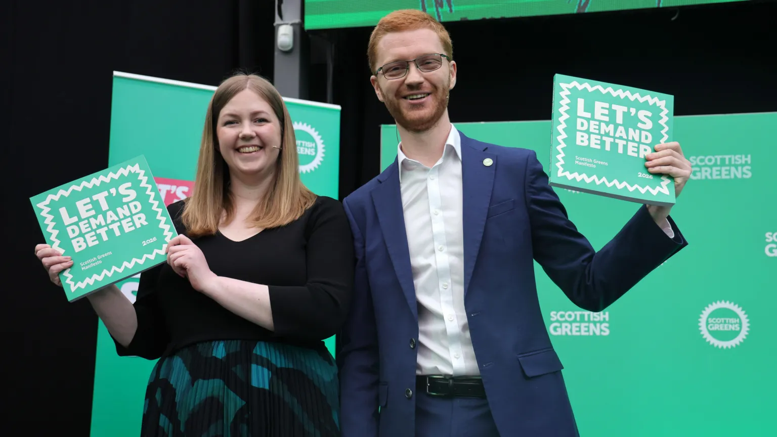  Gillian Mackay and Ross Greer holding up copies of the Scottish Green manifesto