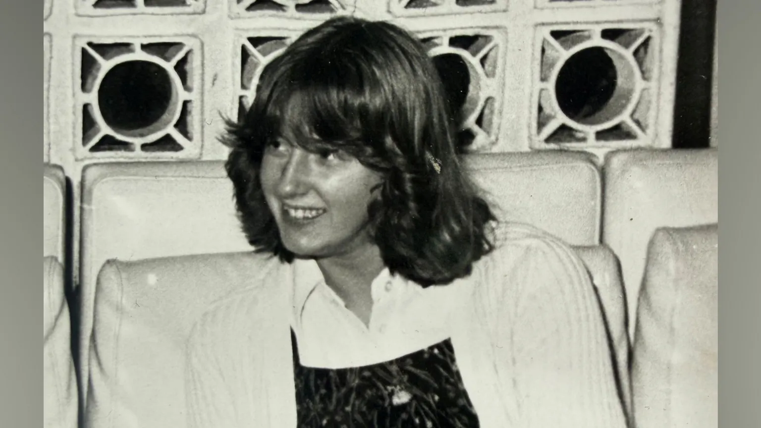 Lynne Darcy An old black and white picture of Lynne Darcy. She is around 14 years ols and has shoulder length hair which is styled and flicked back from her face. She is wearing a white cardigan over a white blouse and darker coloured top. 