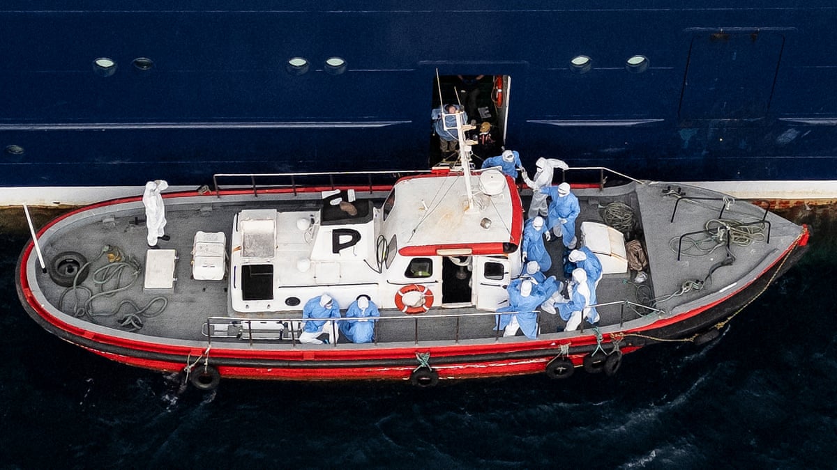 People in hazmat suits on small boat