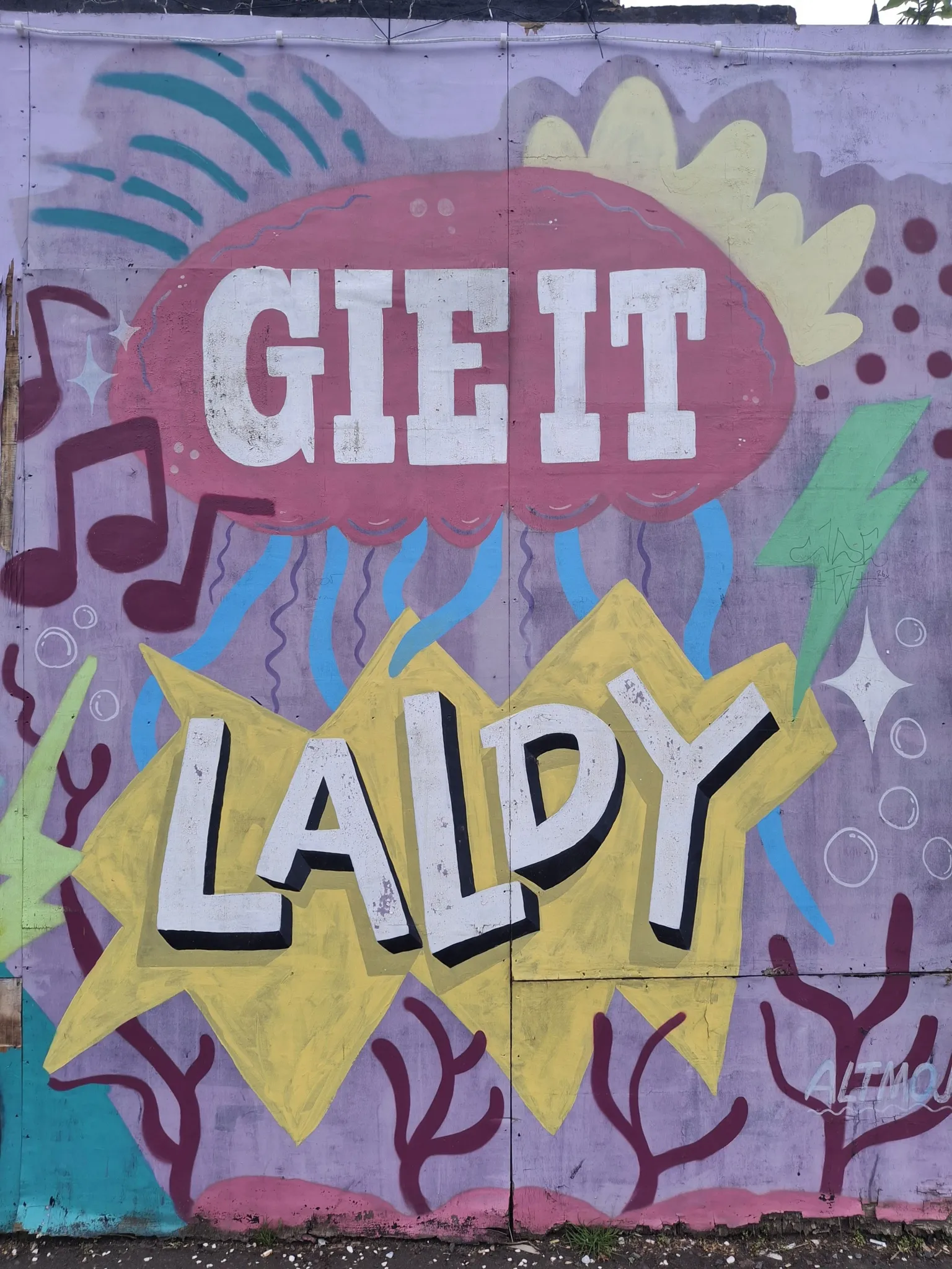 Jenny Scott A large piece of brightly coloured street art, reading GIE IT LALDY.