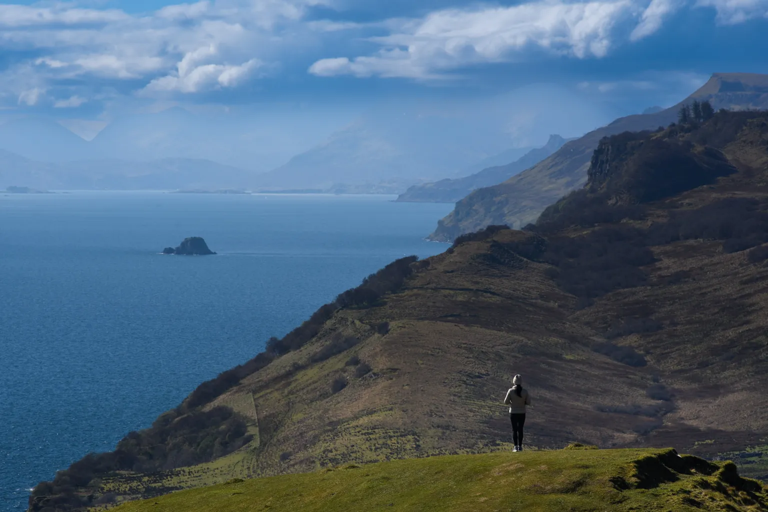Wei Gang A view of the hills and mountains on the Isle of Skye, with the water alongside them.