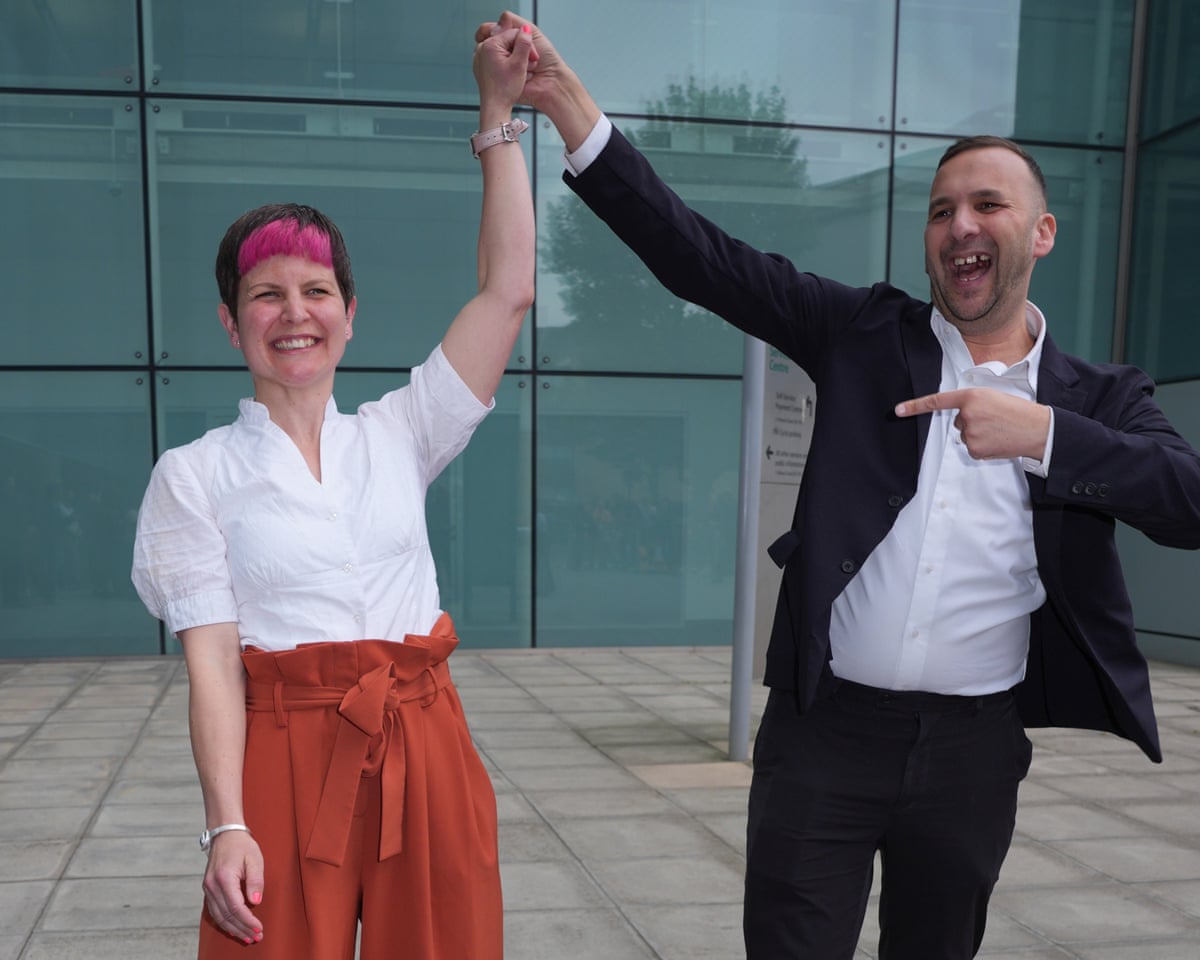 Zoë Garbett and Zack Polanski link hands and raise their arms
