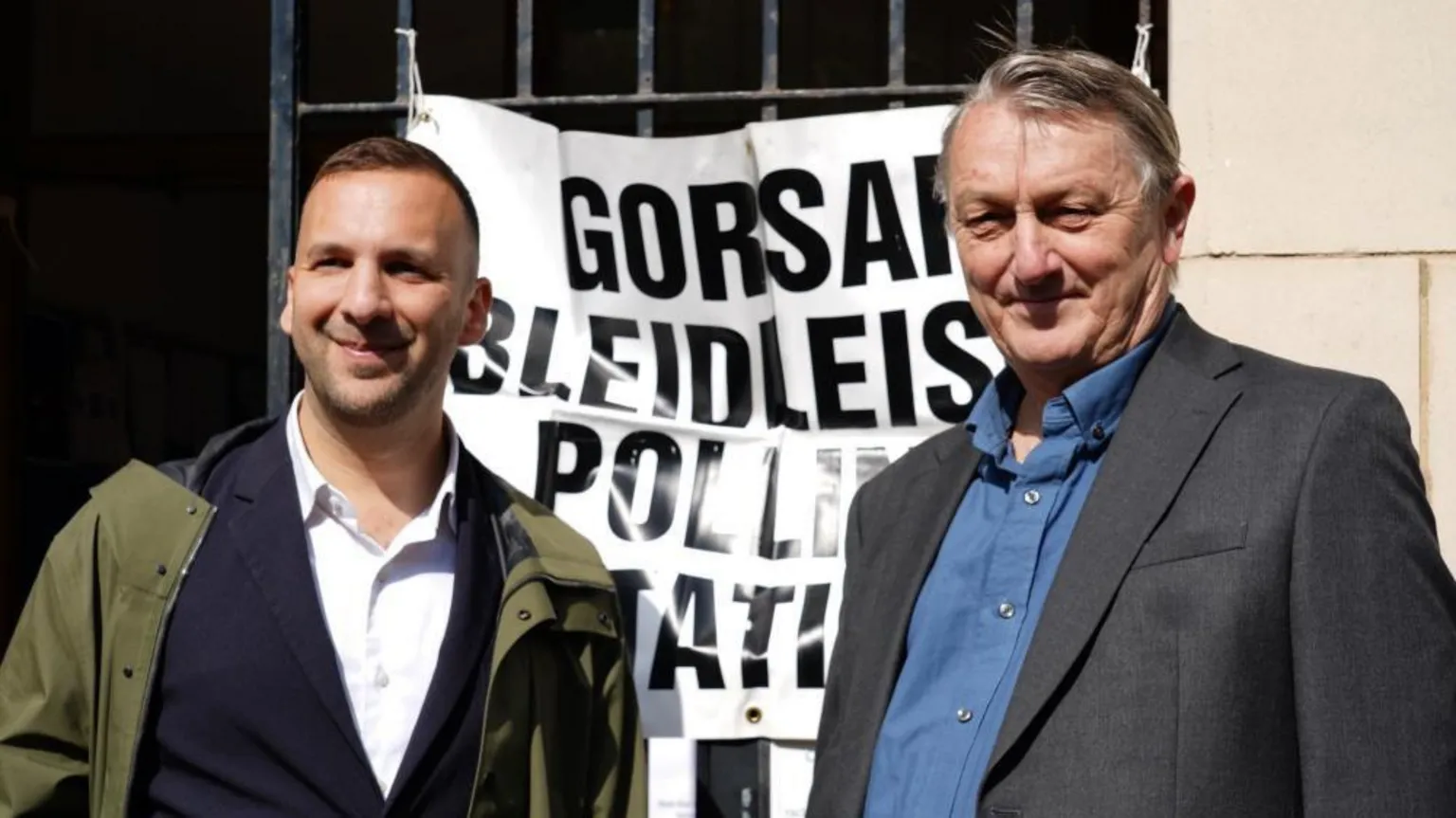 PA Zack Polanski and Wales' Green Party leader Anthony Slaughter, both in suits, standing outside a polling station