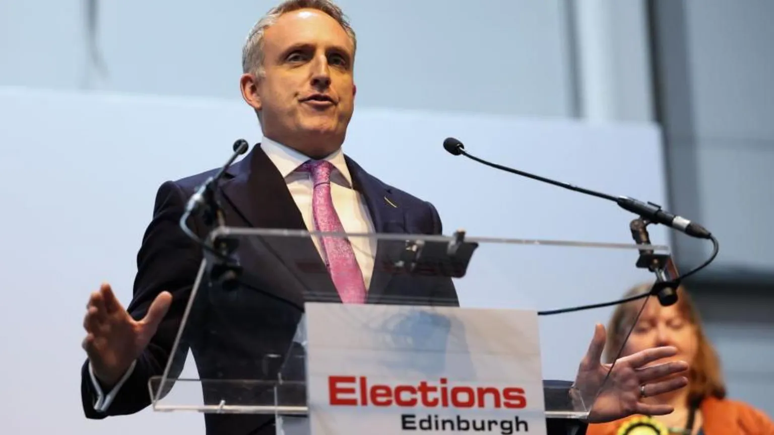  Alex Cole-Hamilton wears a pink tie and suit as he speaks at the Edinburgh election results
