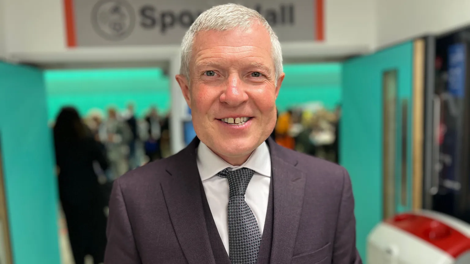  A man smiles while wearing a suit